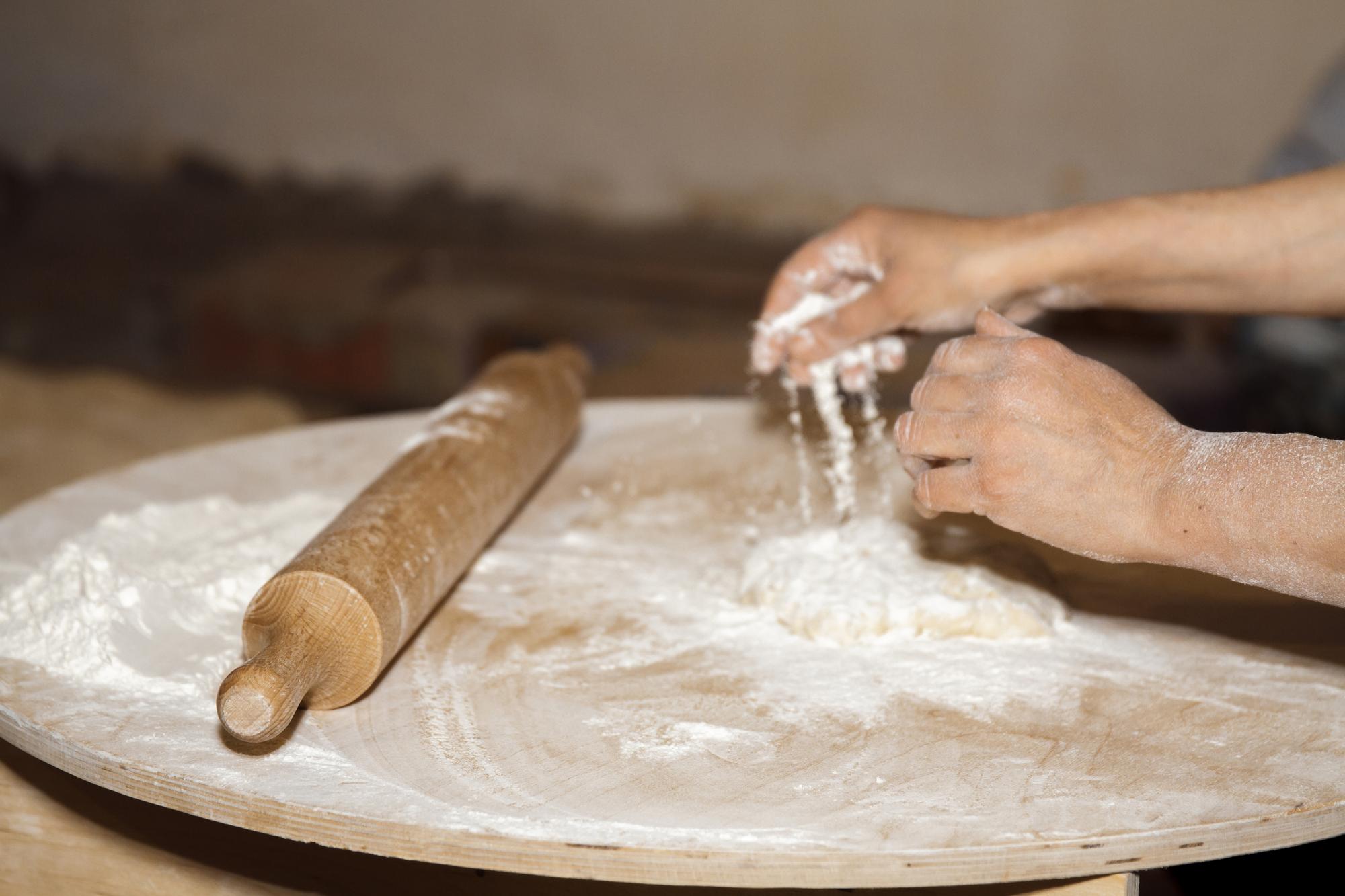 Schmale Hand rollt Teig